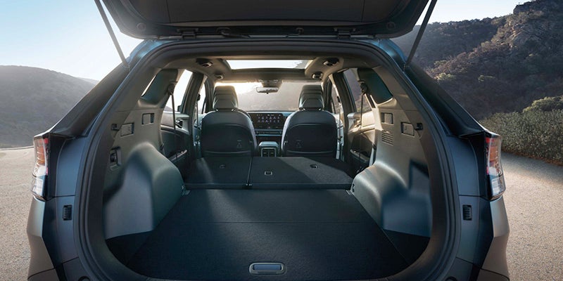 The rear cargo area of kIA is shown with the tailgate open