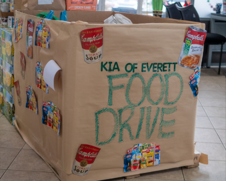 Kia of Everett food drive donation bin decorated with Campbell's soup images.