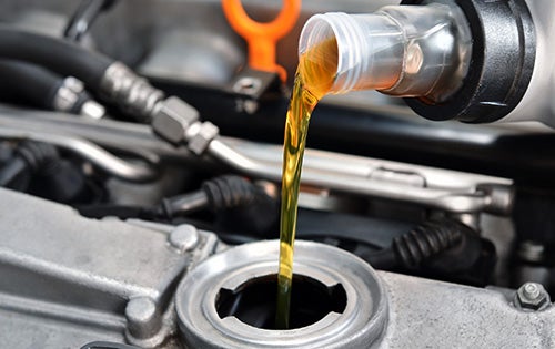 Engine oil being poured into a car engine during an oil change